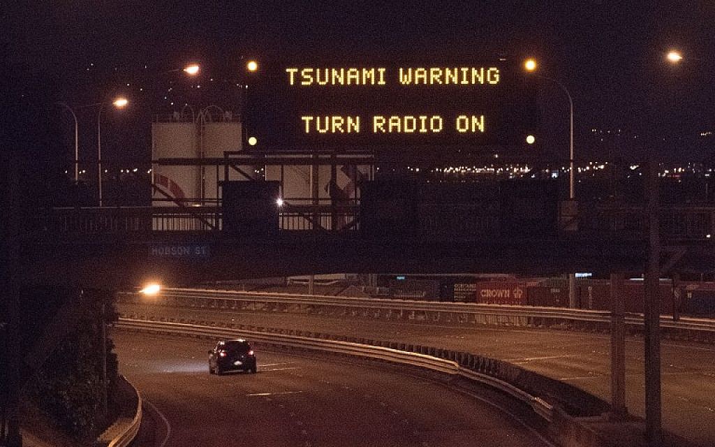 A tsunami warning alert is seen on a notice board above State Highway 1 in Wellington early on November 14, 2016 following an earthquake centered some 90 kilometers (57 miles) north of New Zealand's South Island city of Christchurch.  (AFP PHOTO / Marty Melville)