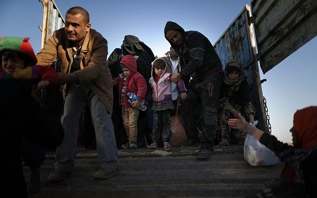 Displaced Iraqi families who fled Mosul due to the ongoing fighting between Iraqi forces and jihadists of the Islamic State (IS) group arrive aboard a truck to be taken to a camp for displaced people, on November 23, 2016 in Bartalla, east of Mosul. (AFP PHOTO / THOMAS COEX)