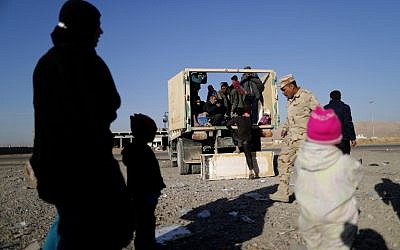Displaced Iraqi families who fled Mosul due to the ongoing fighting between Iraqi forces and jihadists of the Islamic State (IS) group arrive aboard a truck to be taken to a camp for displaced people, on November 23, 2016 in Bartalla, east of Mosul. ( AFP PHOTO / THOMAS COEX)