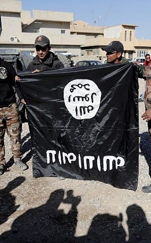 Iraqi army soldiers hold a flag from the Islamic State jihadist group up-side-down on November 23, 2016, near an Iraqi army base in the outskirts of Mosul. (AFP PHOTO/THOMAS COEX)