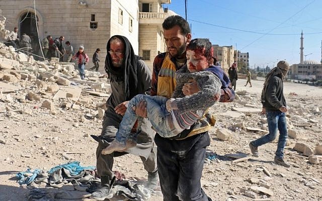 A Syrian civil defence volunteer, known as the White Helmets, carries a boy rescued from the rubble following a reported barrel bomb attack on the northern Syrian city of Aleppo on November 24, 2016. (/ AFP PHOTO / AMEER ALHALBI)