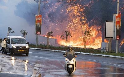 Israelis drive past a fire raging through the northern Israeli port city of Haifa on November 24, 2016. (Jack Guez/AFP)