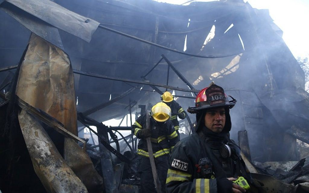 An Israeli firefighter inspects the damages in Beit Meir in the hills to the west of Jerusalem, on November 25, 2016. (AFP/AHMAD GHARABLI)