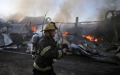 An Israeli firefighter inspects the damage at Beit Meir in the Jerusalem hills, on November 25, 2016. (AFP/Ahmad Gharabli)