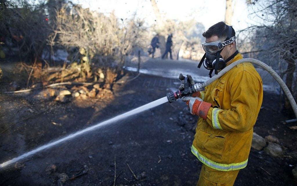 Israeli firefighters extinguish fire in Beit Meir on November 25, 2016. (AFP/AHMAD GHARABLI)