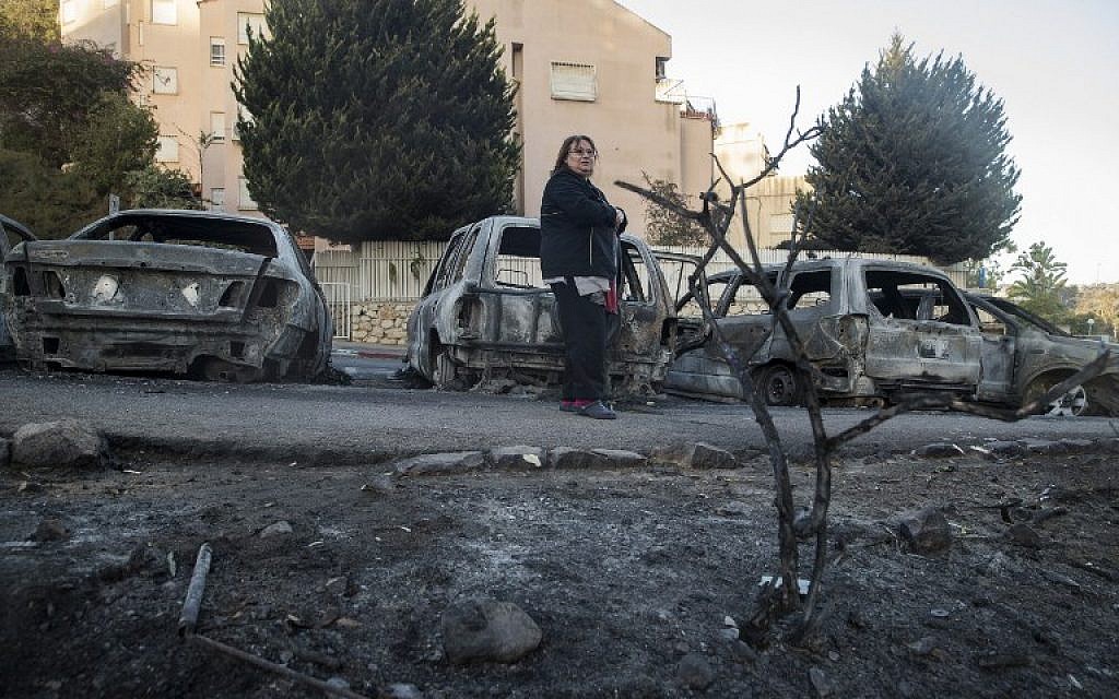 A woman stands amid the damage and burned vehicles in the northern Israeli city of Haifa following a wildfire, on November 25, 2016. (AFP/Jack Guez)