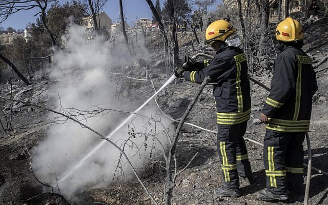 Israeli firefighters extinguish a fire in the northern Israeli city of Haifa following a wildfire, on November 25, 2016. (AFP/ JACK GUEZ) Israeli firefighters extinguish a fire in the northern Israeli city of Haifa following a wildfire, on November 25, 2016. (AFP/ JACK GUEZ)