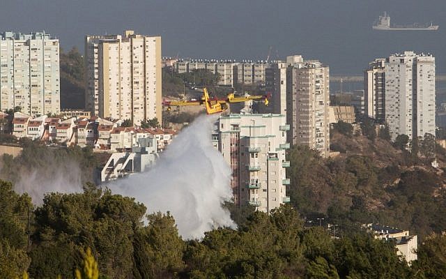 A firefighting plane helps extinguish a blaze in Haifa following a massive wildfire in the northern city, on November 25, 2016. (AFP PHOTO/MENAHEM KAHANA)