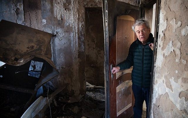 Eitan Shariel inspects the damage inside his house in the northern city of Haifa following a wildfire, on November 25, 2016. ( AFP PHOTO / MENAHEM KAHANA)