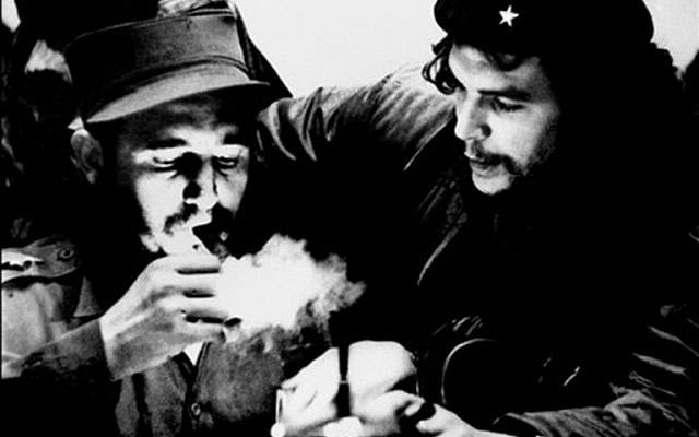 This file photo taken in the 1960s shows then Cuban Prime Minister Fidel Castro (L) lighting a cigar while listens Argentine Ernesto Che Guevara. (AFP PHOTO/CUBADEBATE/Roberto SALAS)