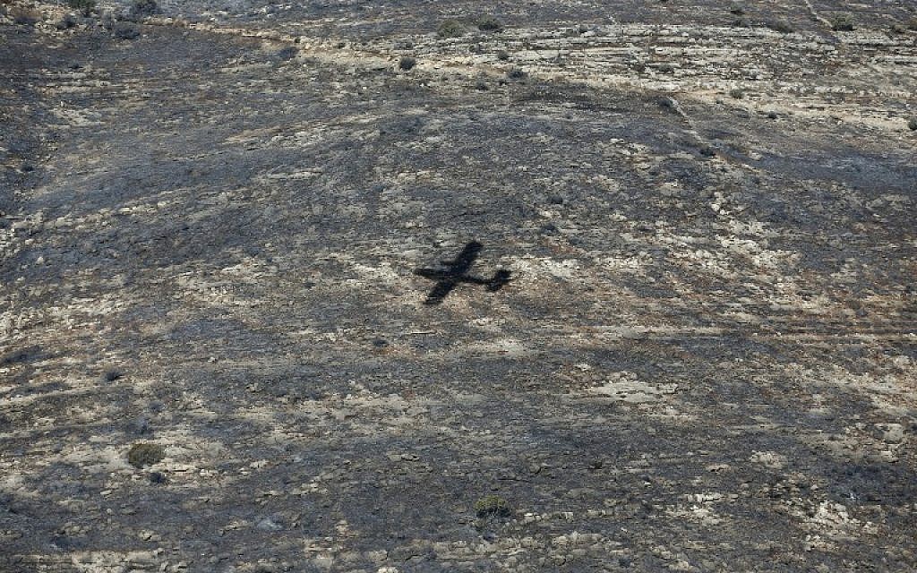 The shadow of a Turkish firefighter jet is seen as it flies over the village of Nataf close to Jerusalem, to help extinguish the ongoing fire in the area, on November 26, 2016. (AFP PHOTO/AHMAD GHARABLI) The shadow of a Turkish firefighter jet is seen as it flies over the village of Nataf close to Jerusalem, to help extinguish the ongoing fire in the area, on November 26, 2016. (AFP PHOTO/AHMAD GHARABLI)