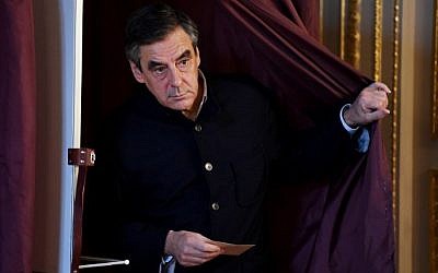 French member of Parliament and candidate for the right-wing primaries ahead of the 2017 presidential elections, Francois Fillon, walks out out the voting booth in a polling station in Paris, on November 27, 2016, during the second round of the primary. (AFP PHOTO/POOL/ERIC FEFERBERG)