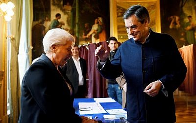 French presidential candidate Francois Fillon (R) gestures before casting his ballot in a polling station in Paris, on November 27, 2016, during the second round of the primary.(AFP PHOTO / POOL / Eric FEFERBERG)