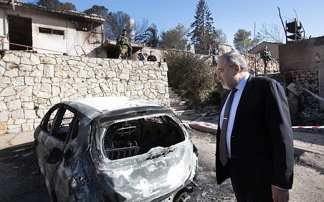 Avigdor Lieberman inspects burnt houses in the Halamish settlement on November 27, 2016. AFP/ MENAHEM KAHANA)