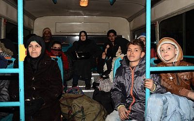 Syrian families, from various eastern districts of Aleppo, are evacuated by bus through Sheikh Maqsud, a Kurdish-controlled enclave between the government-held west of Aleppo and the east, on November 27, 2016 (AFP PHOTO / GEORGE OURFALIAN)