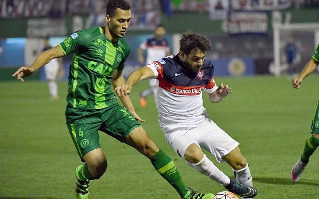 This photo taken on November 23, 2016 shows Neto (L) of Brazil's Chapecoense vying for the ball with Ezequiel Cerutti (R) of Argentina's San Lorenzo, during their 2016 Copa Sudamericana semifinal second leg football match held at Arena Conda stadium, in Chapeco, Brazil. NEto was confrirmed to have been rescued from the crash of the team plane. (UNGRD). / AFP PHOTO / NELSON ALMEIDA