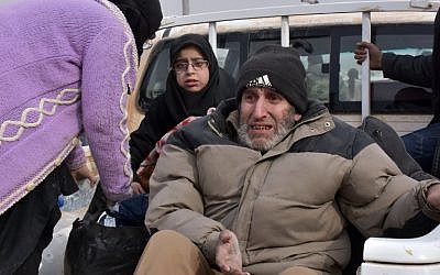 Syrian families, fleeing from various eastern districts of Aleppo, wait to board vehicles on November 29, 2016 in the government-held eastern neighborhood of Jabal Badro, before heading to government-controlled western Aleppo, as the Syrian government offensive to recapture rebel-held Aleppo has prompted an exodus of civilians. (AFP PHOTO / George OURFALIAN)