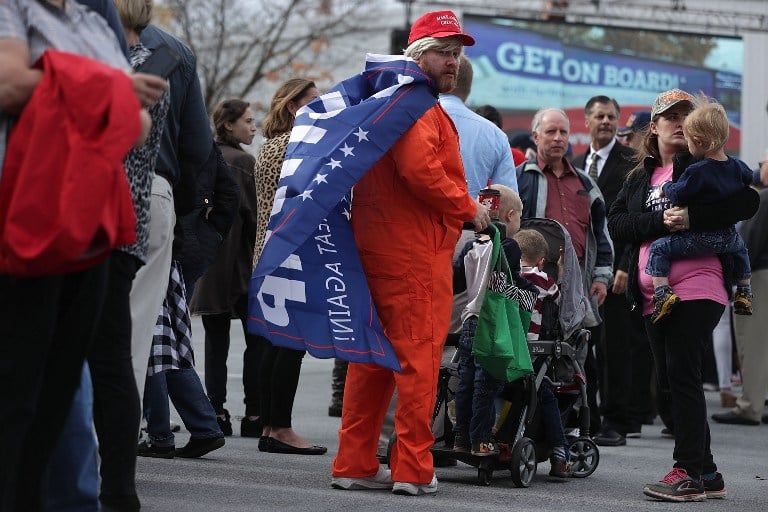 With a Trump flag on his back, Evan Vittoriano of Bensalem, Pennsylvania, waits in-line with his family for a Trump campaign event November 3, 2016 in Berwyn, Pennsylvania. (Alex Wong/Getty Images/AFP)