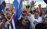 People dance together as they react to the news of the death of former Cuban President Fidel Castro outside the restaurant Versailles on November 26, 2016 in Miami, Florida. (Joe Raedle/Getty Images North America/AFP)