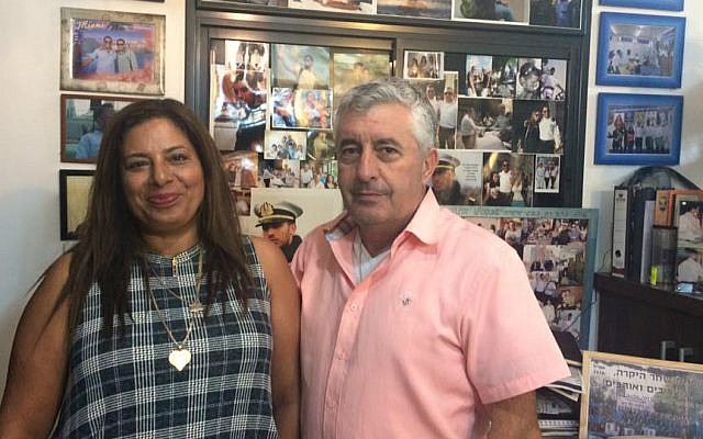 Irit and Asher Shahar in front of the memorial to their son Omri they have created in their home. (Renee Ghert-Zand/TOI)