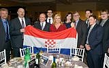 Croatian President Kolinda Grabar-Kitarovic poses during a recent trip to Canada with a flag carrying a symbol of her country's wartime pro-Nazi regime. (Facebook)