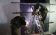 Israeli soldiers weld shut a workshop allegedly used to manufacture illegal guns in Yatta, outside Hebron, early in the morning on November 8, 2016. (IDF Spokesperson's Unit)