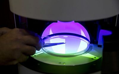 A Sarine Technologies Ltd. employee puts a diamond in a machine that can instantly grade the clarity of polished diamonds in Ramat Gan, Israel, on Thursday, Nov. 10, 2016. (AP Photo/Ariel Schalit)