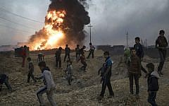 Children play next to a burning oil field in Qayara, south of Mosul, Iraq, Thursday, Nov. 3, 2016. (AP Photo/Felipe Dana)