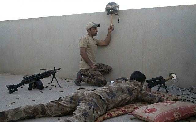 An Iraqi special forces soldier puts up a helmet as a decoy while a sniper gets ready to fire on Islamic State positions in Gogjali, on the eastern edges of Mosul, Iraq, Thursday, Nov. 3, 2016. (AP Photo/Marko Drobnjakovic)
