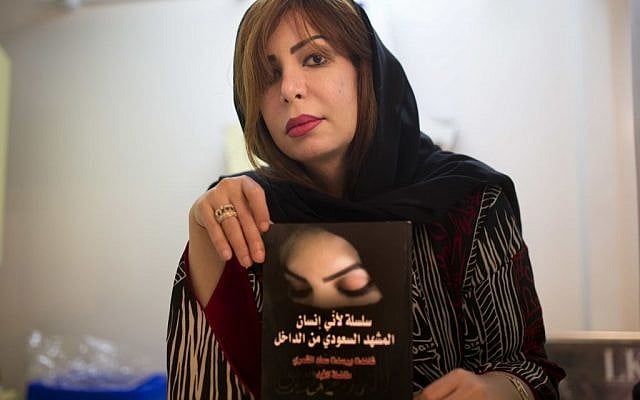Saudi women's rights activist Souad al-Shammary holds a copy from her forbidden book in Saudi, "because I'm a human, the Saudi scene from inside", in Jiddah, Saudi Arabia, Saturday, May 7, 2016. (AP Photo)