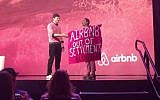 A protester against Airbnb's listing of West Bank settlement rentals during an interview with Ashton Kutcher at Airbnb Open in Los Angeles. November 19, 2016 (Screen capture: YouTube)