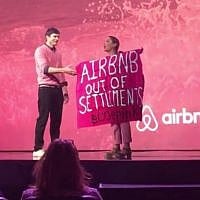 A protester against Airbnb's listing of West Bank settlement rentals during an interview with Ashton Kutcher at Airbnb Open in Los Angeles. November 19, 2016 (Screen capture: YouTube)