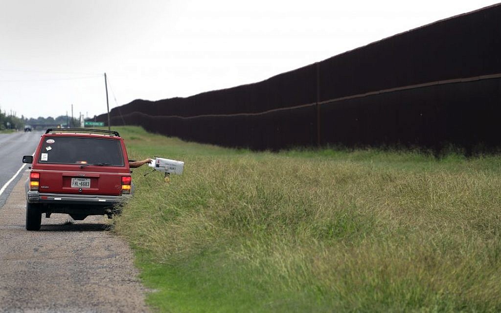 In this Monday, Nov. 14, 2016, photo, a carrier delivers mail along a section of border fence in Brownsville, Texas. The idea of a concrete wall spanning the entire 1,954-mile southwest frontier collides head-on with multiple realities, like a looping Rio Grande, fierce local resistance, and cost. (AP Photo/Eric Gay) In this Monday, Nov. 14, 2016, photo, a carrier delivers mail along a section of border fence in Brownsville, Texas. The idea of a concrete wall spanning the entire 1,954-mile southwest frontier collides head-on with multiple realities, like a looping Rio Grande, fierce local resistance, and cost. (AP Photo/Eric Gay)