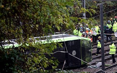 Emergency service workers attend the scene of a derailed tram in Croydon, south London, November 9, 2016. (Steve Parsons/PA via AP)