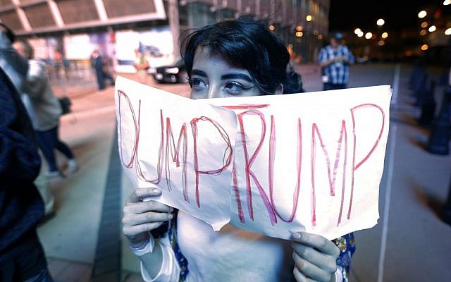 Jennifer Quinones of Garland, Texas, holds up a sign as she joins others gathered to protest President-elect Donald Trump's victory, Wednesday, Nov. 9, 2016, in Dallas. (AP Photo/Tony Gutierrez) Jennifer Quinones of Garland, Texas, holds up a sign as she joins others gathered to protest President-elect Donald Trump's victory, Wednesday, Nov. 9, 2016, in Dallas. (AP Photo/Tony Gutierrez)