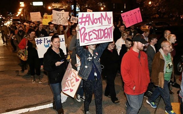 Protesters holds up signs in opposition of Donald Trump's presidential election victory as they march from Jefferson Square Park, Thursday, Nov. 10, 2016 in Louisville, Kentucky. (AP Photo/Timothy D. Easley)