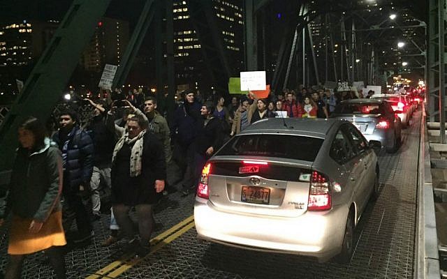 Protesters cross the Hawthorne Bridge in Portland, Oregon, on the third day of protests over the results of the 2016 US presidential election, Thursday, Nov. 10, 2016. (Jim Ryan/The Oregonian via AP)