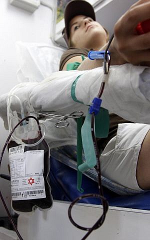 A young girl gives blood at a Magen David Adom emergency services blood donation mobile center on July 9, 2008. (Daniel Dreifuss/Flash90)