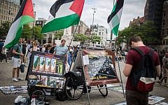 Illustrative: Israeli tourists look at a BDS stand with photos and Palestinian flags, calling to 'Free Palestine,' at Dam Square in central Amsterdam, the Netherlands, on June 24, 2016. (Hadas Parush/Flash90)