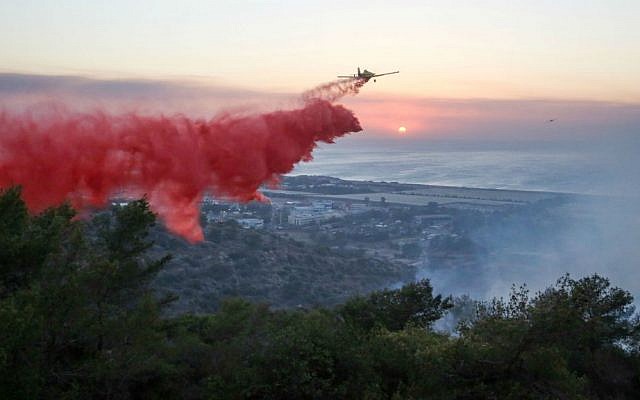 Israeli firefighter airplanes try to extinguish a fire raging in the northern city of Haifa, where a major fire was raging across the city on November 24, 2016. (Yaakov Cohen/Flash90)