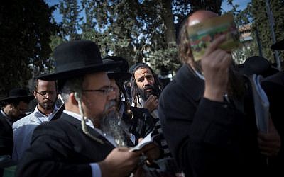 Ultra-Orthodox Jewish men gather to pray during a demonstration in support of Rabbi Eliezer Berland outside the Magistrate's court in Jerusalem where Berland was sentenced to prison for indecent acts and assault, on November 22, 2016. (Photo by Yonatan Sindel/ Flash90)