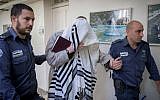 Rabbi Eliezer Berland covers himself with his talit (prayer shawl) at the Magistrate Court in Jerusalem where he was sentenced to prison for indecent acts and assault, on November 22, 2016. (Photo by Yonatan Sindel/ Flash90)