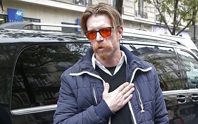 American singer Jesse Hughes of Eagles of Death Metal puts his hand over his heart as he leaves the ceremony at the Bataclan concert hall in Paris, Sunday, November 13, 2016. (AP Photo/Michel Euler)