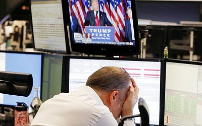 A broker reacts as President-elect Donald Trump shows up on a television screen at the stock market in Frankfurt, Germany, Wednesday, Nov. 9, 2016. (AP Photo/Michael Probst)