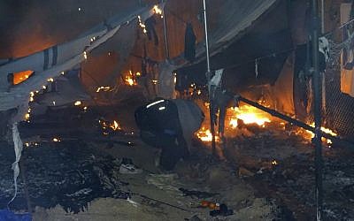 A refugee tries to save his belongings as a fire burns at the Moria refugee camp on the northeastern Greek island of Lesbos, early Friday, Nov. 25, 2016. (AP Photo)