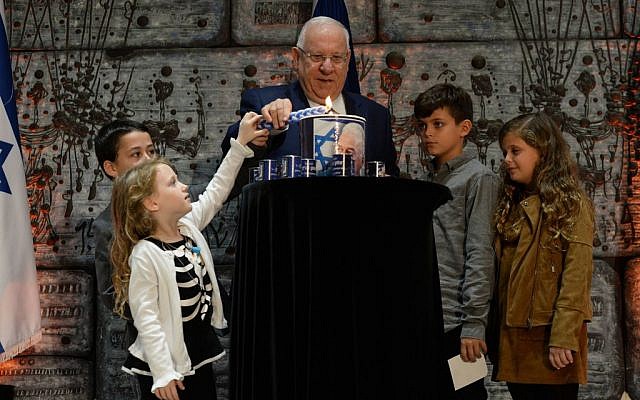 Children help President Reuven Rivlin light a candle to mark the 21st anniversary of the assassination of late prime minister Yitzhak Rabin on November 11, 2016 (Chaim Zach / GPO)