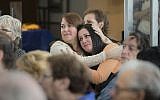 In this Oct. 30, 2016 photo Lorrie Zullo, left, and Jillian Eisman embrace at the Kupferberg Holocaust Center at Queensborough Community College in the Queens borough of New York. (Leo Correa/Queensborough Community College via AP)