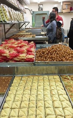 Trays of honey-laden sweets at one of the bakeries in the market (Jessica Steinberg/Times of Israel)