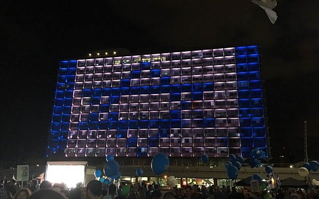 An Israeli flag lights up the municipal building in Tel Aviv as tens of thousands gather in Rabin Square to mark the 21st anniversary of the prime minister’s assassination on November 5, 2016 (Iacopo Luzi)