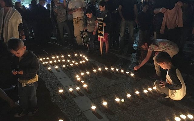Young Israelis spell the word 'Shalom' (peace) with candles at a rally marking 21 years since his assassination, at Tel Aviv’s Rabin Square on November 5, 2016 (Iacopo Luzi)